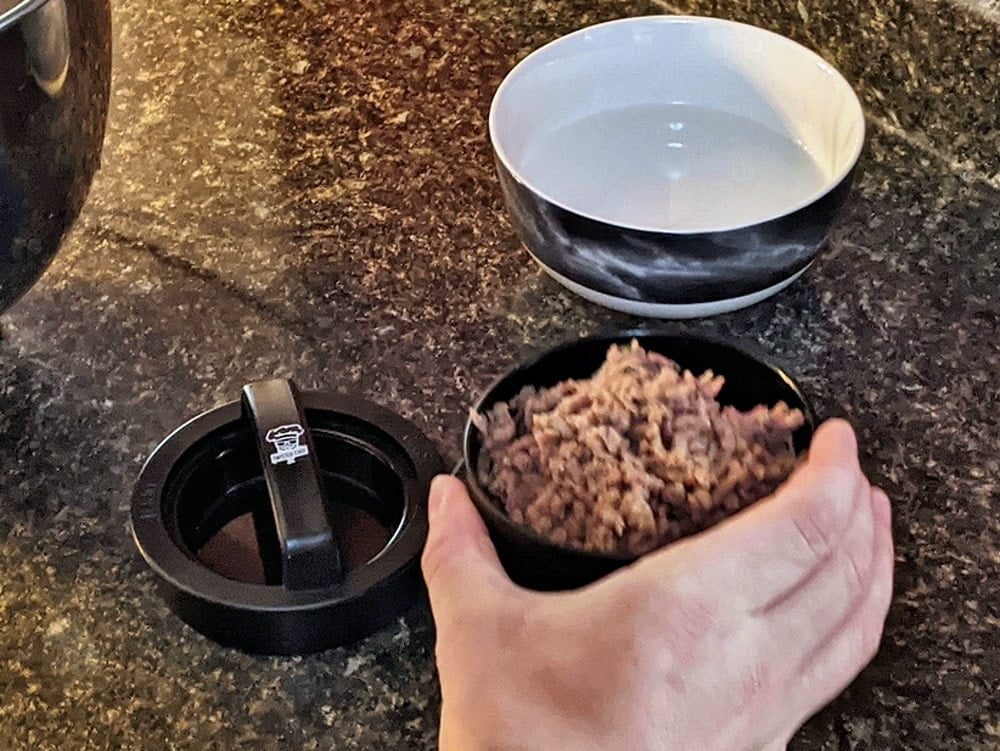 adding meat to stuffed burger press